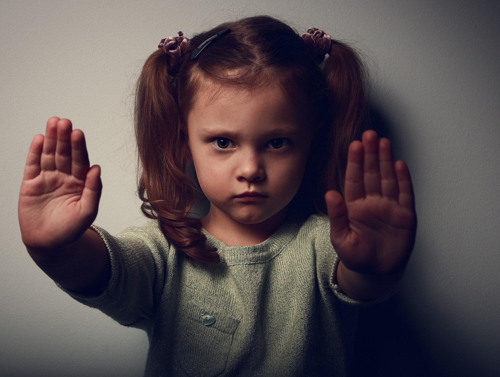 Child holding both palms forward in a stop gesture