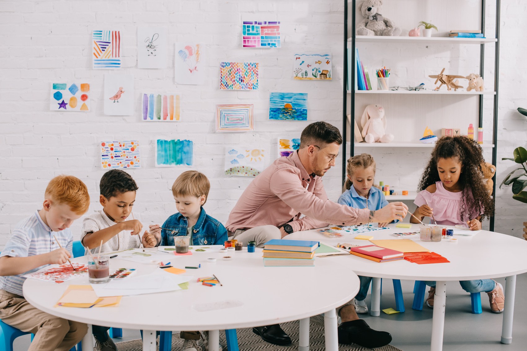 Teacher guiding children through creative classroom activities